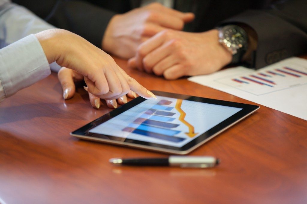 Girl pointing at bar graph on the iPad