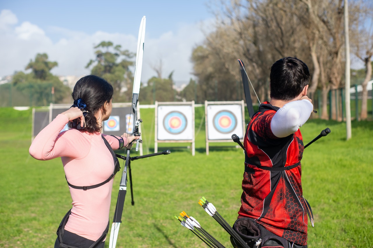 man and woman doing archery