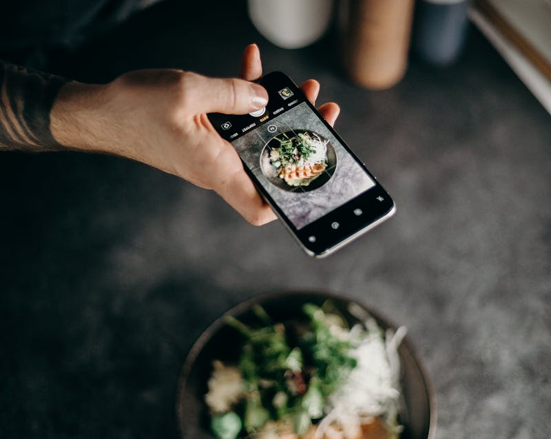 taking a photo of food before posting on Instagram